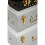 Stacked metal storage trunks with gold latches in black and white finish