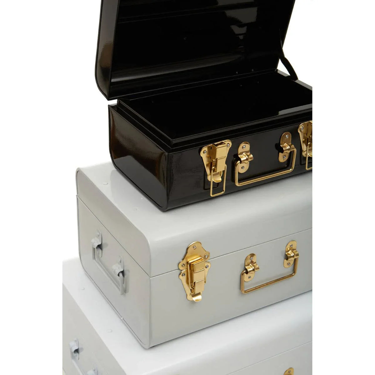 Stacked metal storage trunks with gold clasps, black trunk open on top, grey trunks below