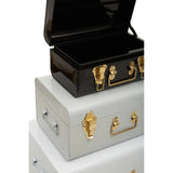 Stacked metal storage trunks with gold clasps, black trunk open on top, grey trunks below