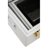 Closeup of white metal storage trunk with gold latch and black interior compartment