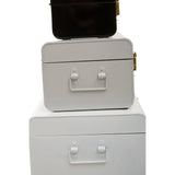 Stacked metal storage trunks in black and white with side handles and gold clasps