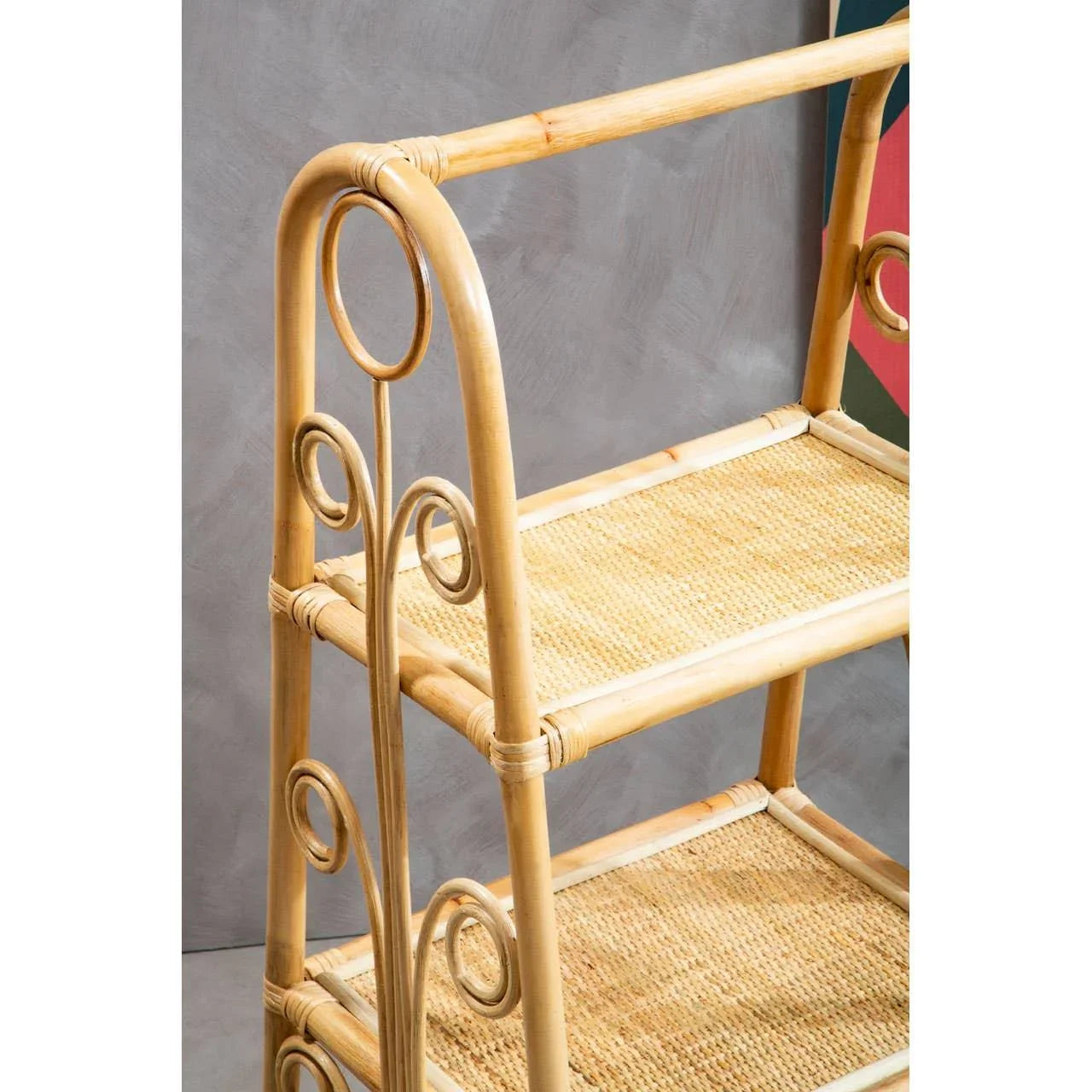 Three tier rattan shelving unit with decorative side loops and woven shelves