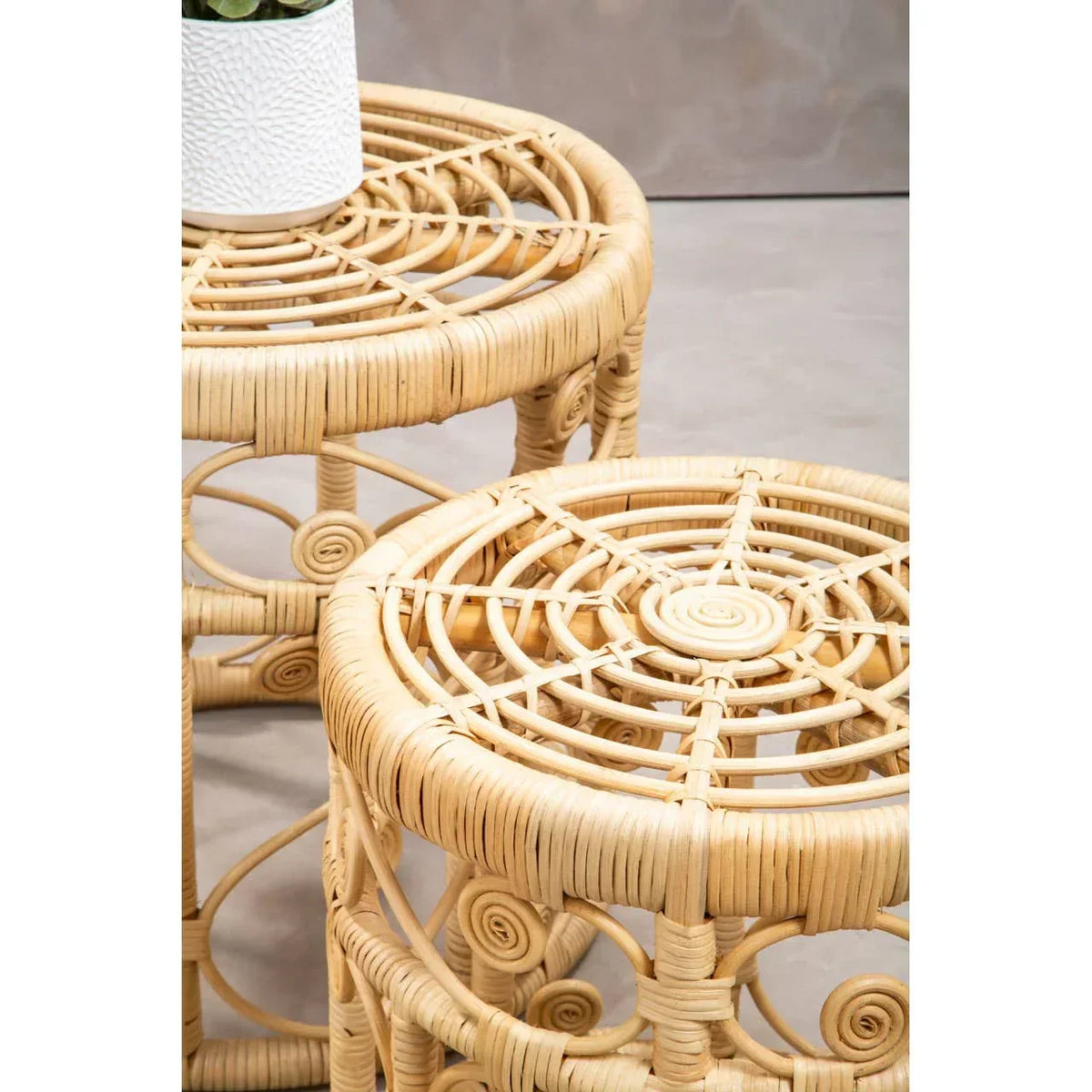 Round rattan side table set with woven tops and spiral detailing, close-up view