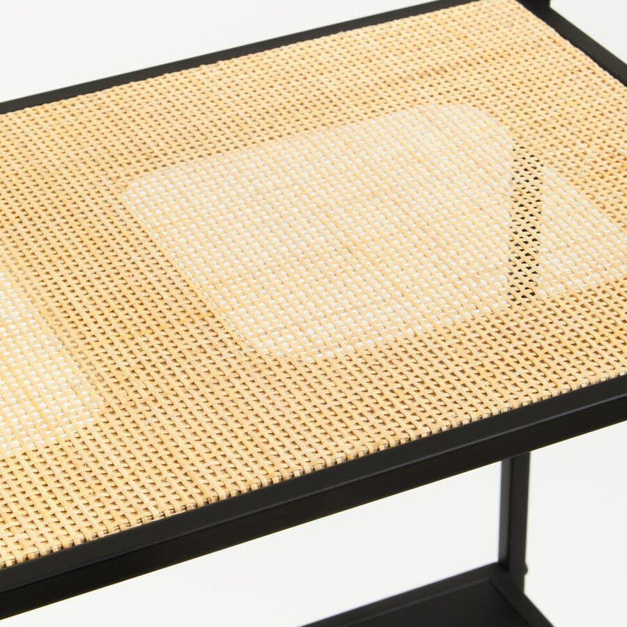 Close-up of woven rattan shelf with black metal frame, modern furniture detail