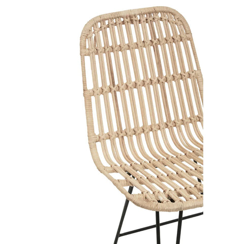 Close-up of rattan dining chair with natural woven seat and black metal legs