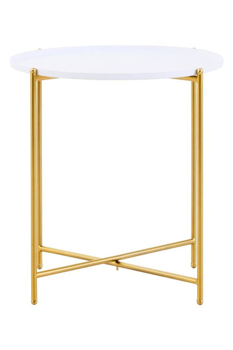 Round white tabletop supported by a sleek gold metal frame with crossed legs, designed as a modern side table