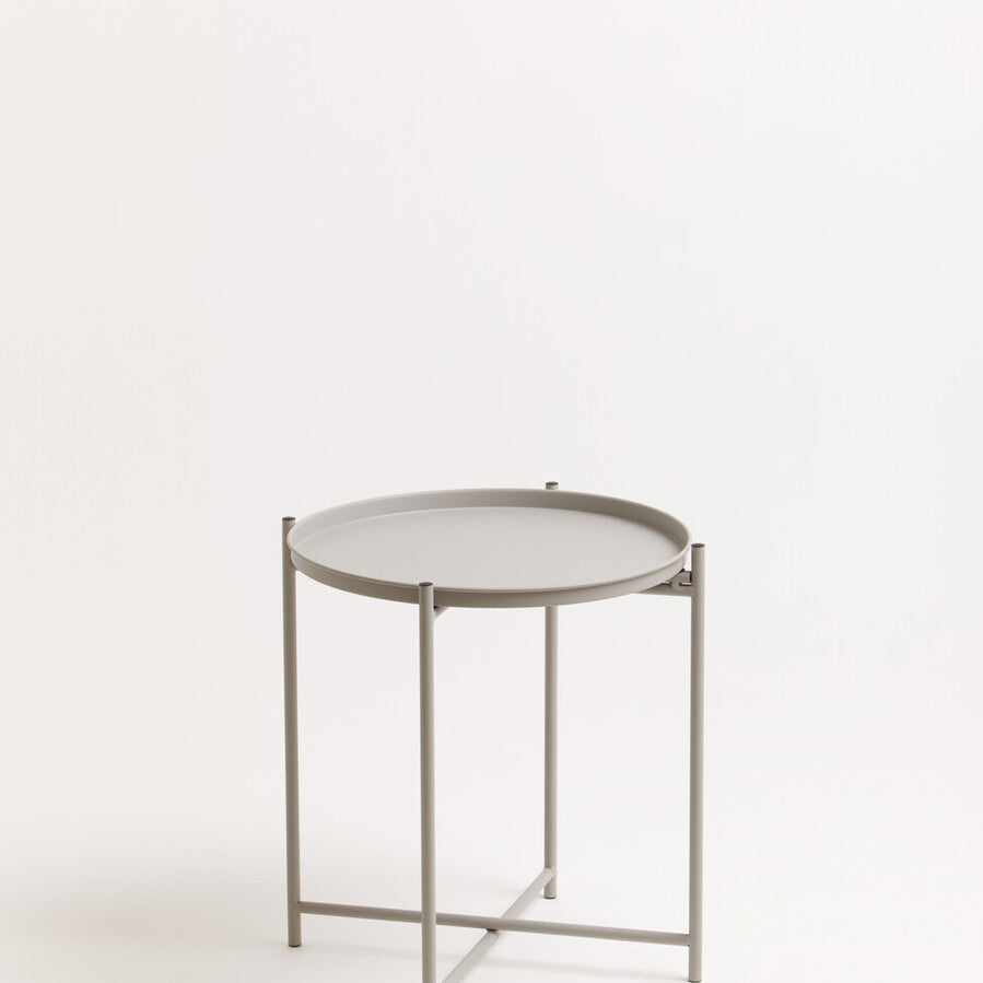 Grey iron side table with a round top and a minimalist design, featuring a sturdy three-legged base and a sleek finish, set against a plain white background