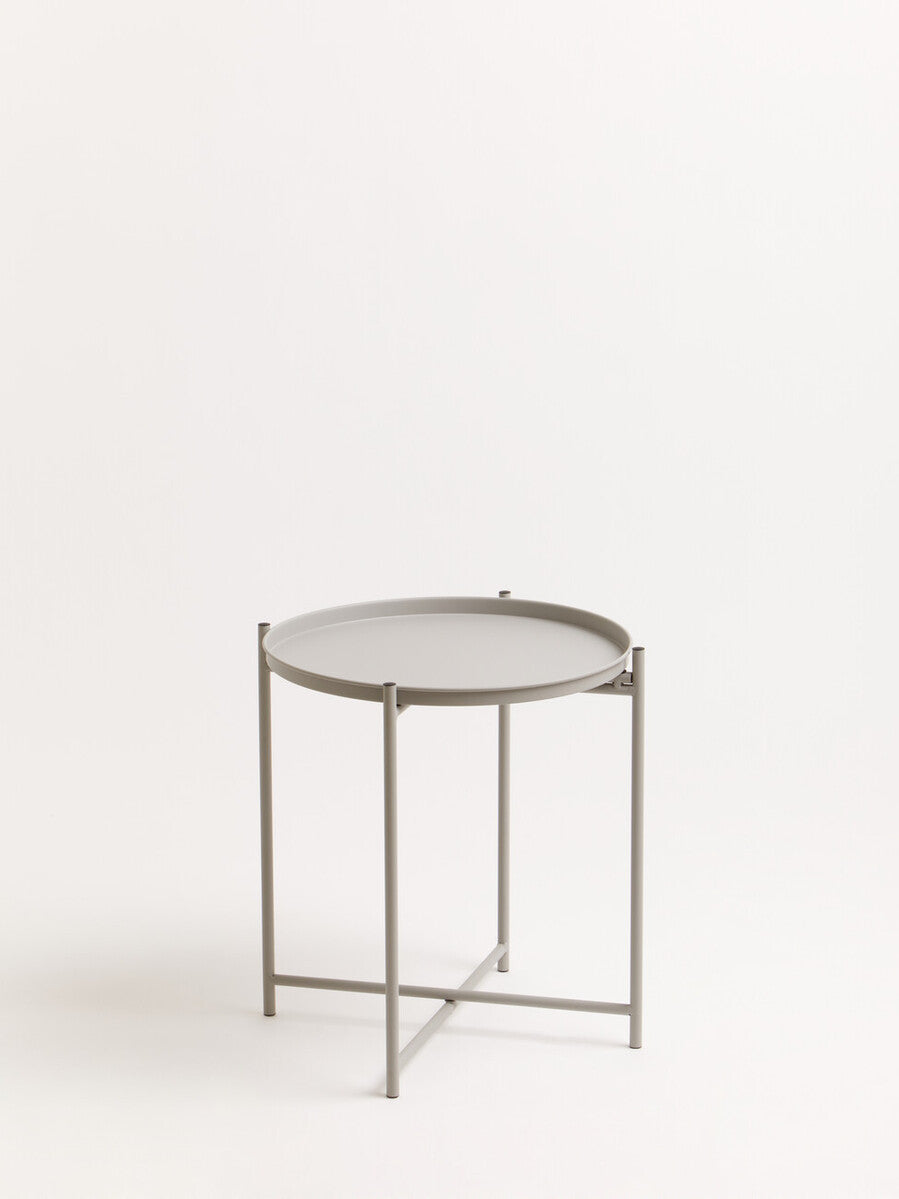 Grey iron side table with a round top and a minimalist design, featuring a sturdy three-legged base and a sleek finish, set against a plain white background