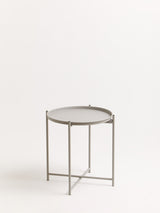 Grey iron side table with a round top and a minimalist design, featuring a sturdy three-legged base and a sleek finish, set against a plain white background