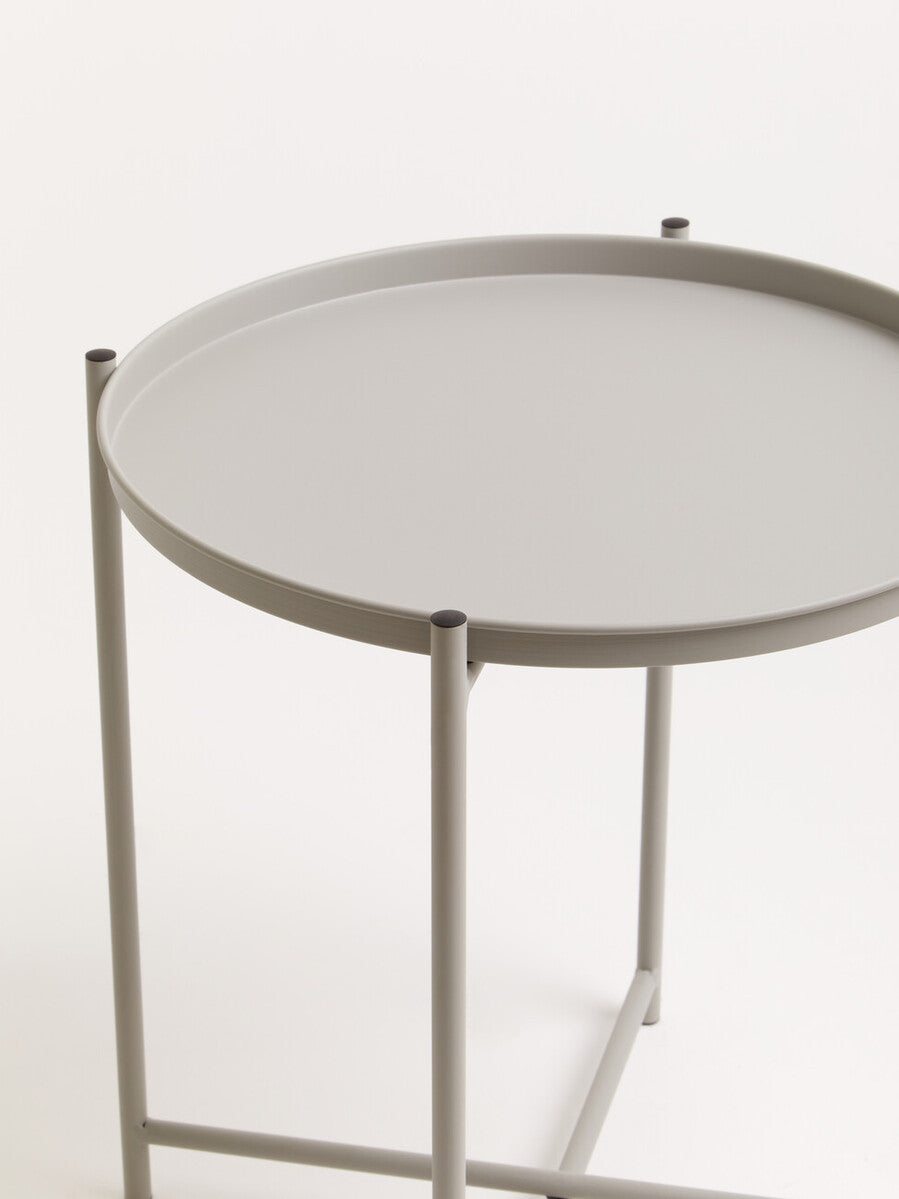 Round grey iron side table with a smooth top and slender legs, featuring a minimalist design suitable for modern home decor