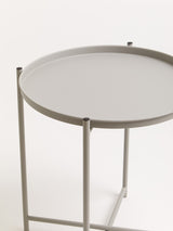 Round grey iron side table with a smooth top and slender legs, featuring a minimalist design suitable for modern home decor