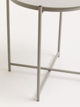 Grey iron side table featuring a round top and slender legs with a crossbar for stability, set against a neutral background