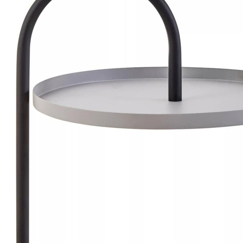 A modern side table featuring a circular grey tabletop with a sleek black metal frame. The frame has a curved handle design that arches over the tabletop, creating a minimalist and stylish look suitable for contemporary home decor