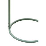 Green metal side table with a circular base and a slender vertical support, designed to hang from a surface. The table features a minimalist style, showcasing a smooth finish and a modern aesthetic