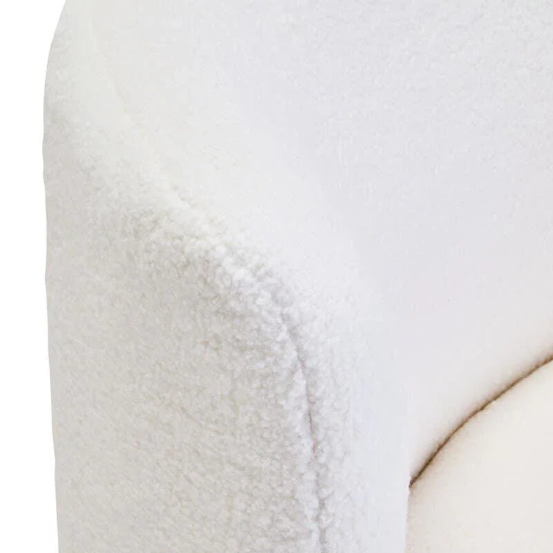 Close-up of white boucle fabric armchair corner with curved arm and soft upholstery