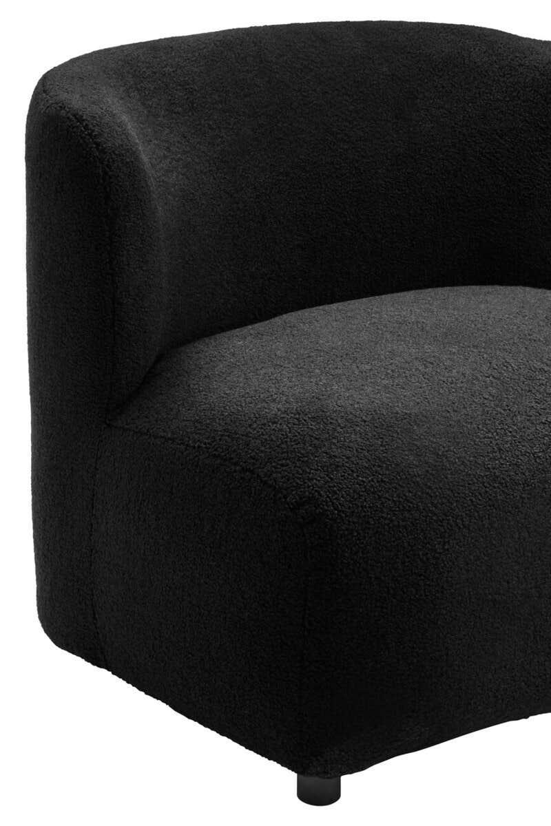 Curved black accent chair with soft textured upholstery and low profile armrest