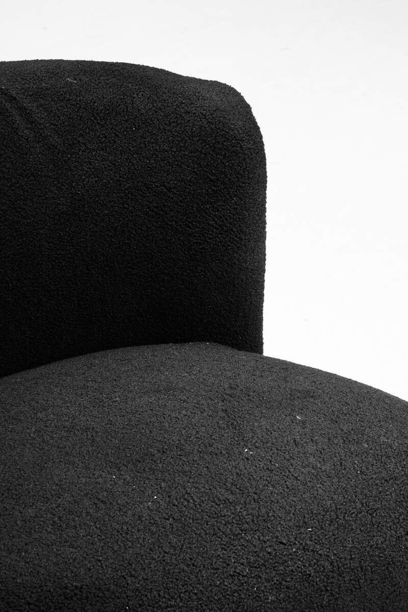 Close-up of black boucle fabric armchair with curved backrest