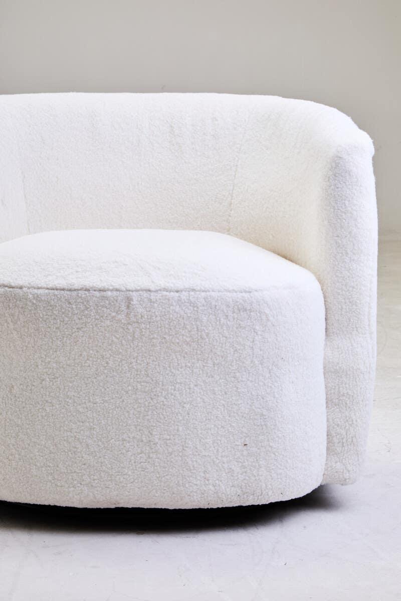 Curved boucle armchair in white fabric with modern silhouette, close-up angle