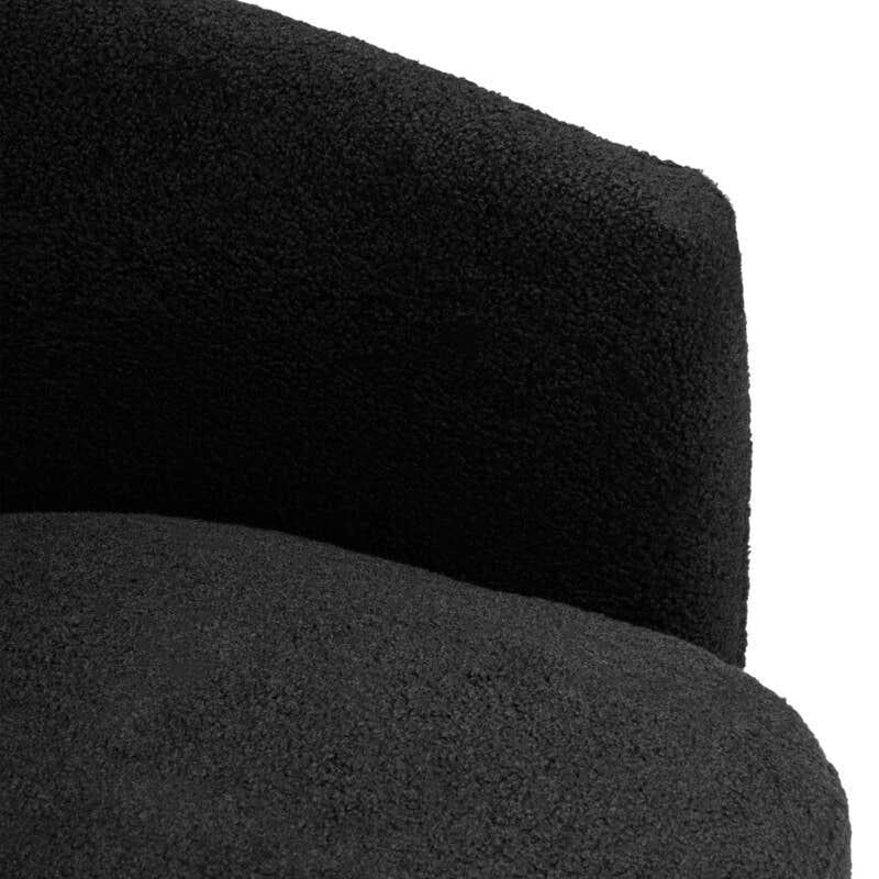 Close-up of textured black fabric accent chair with curved backrest