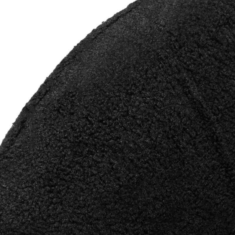 Closeup of textured black fabric upholstery on curved furniture armrest