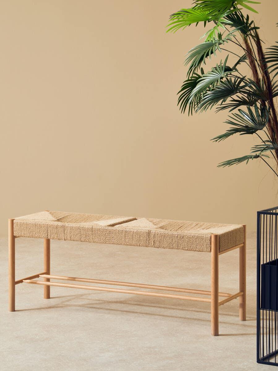 Natural woven bench with wooden frame and plant decor in modern living space