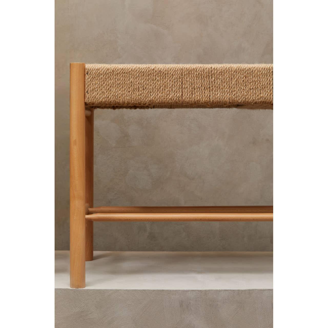 Close view of wooden bench with natural woven rope seat and light wood legs
