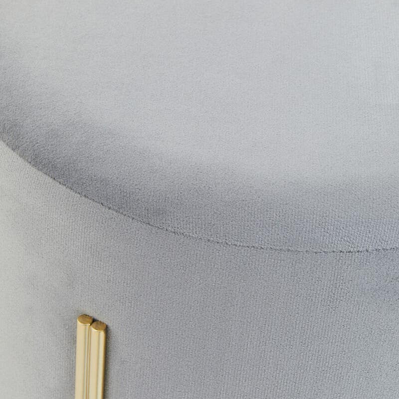 Round grey velvet stool with a smooth top surface and gold metal legs, showcasing a modern and elegant design
