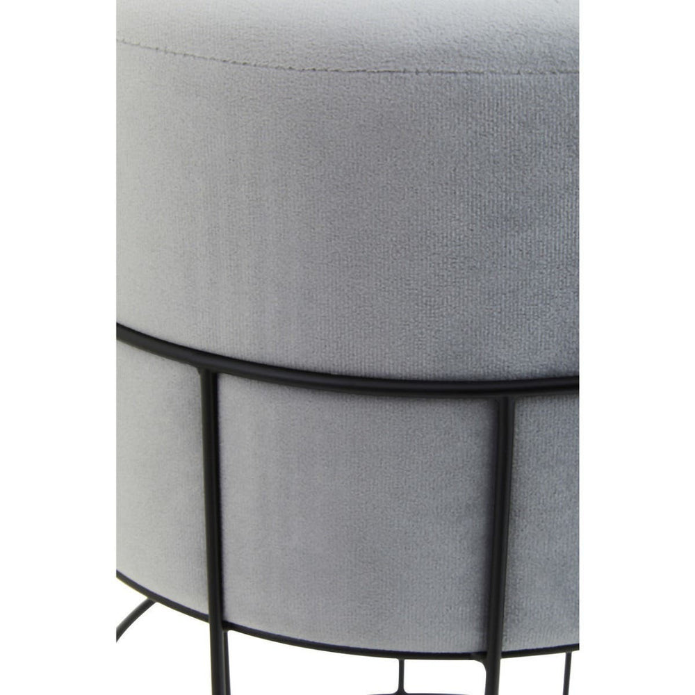 Round velvet stool in a light gray color, featuring a sleek black metal cage frame. The design showcases a smooth, plush top and a minimalist structure with four slender legs