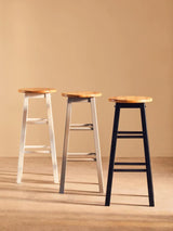 Set of three wooden bar stools with white, grey, and black legs on neutral background