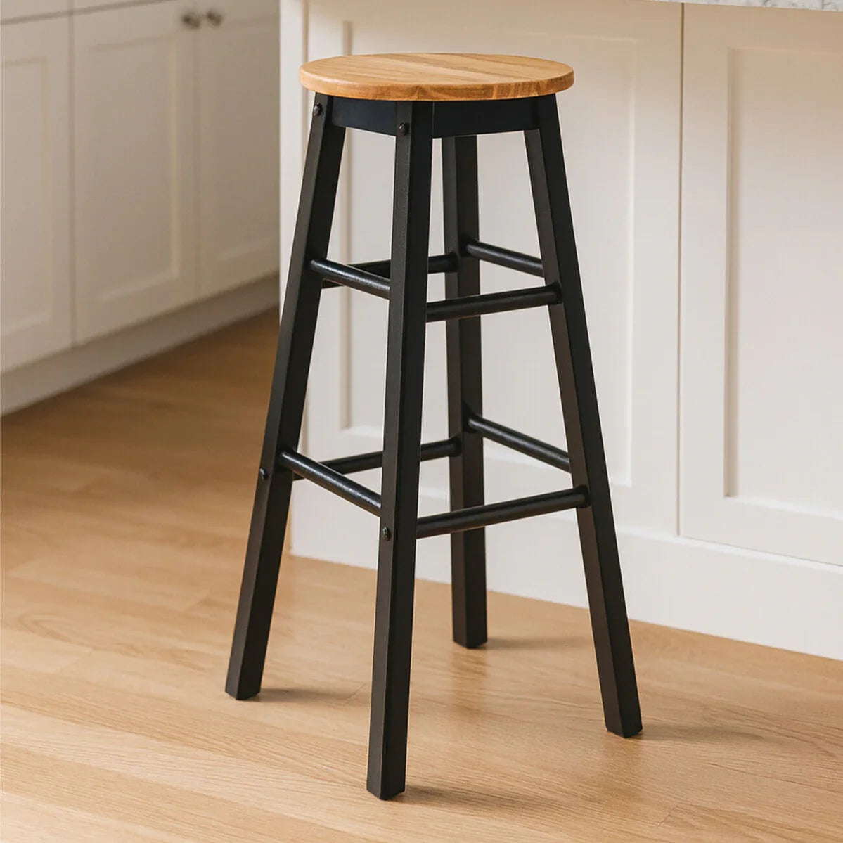 Black metal bar stool with wooden seat beside kitchen island on wood floor