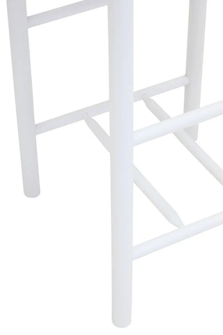 White wooden stool legs and footrest close-up
