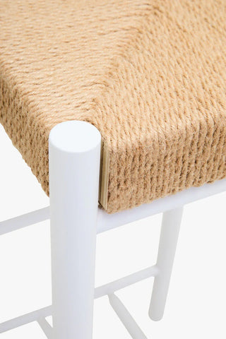 Closeup of woven rope seat on white metal chair
