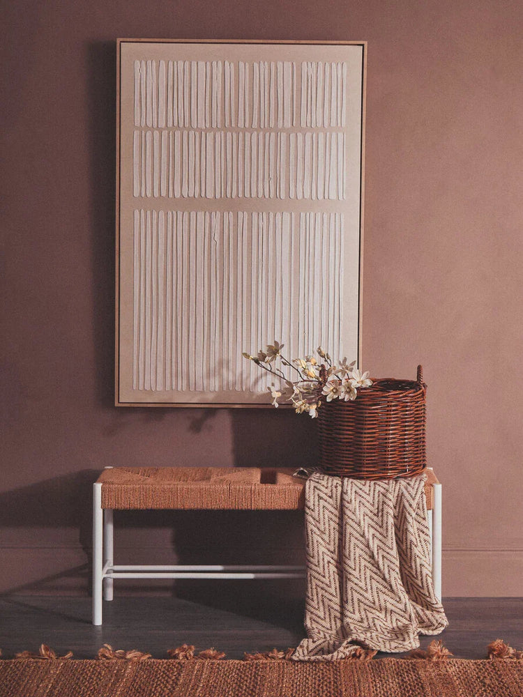 Woven bench with metal legs, wicker basket, and chevron blanket in modern hallway decor