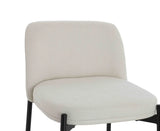 Cream upholstered dining chair with black metal legs, close view of seat and backrest