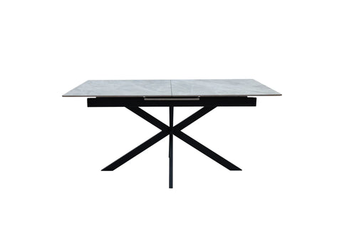A modern rectangular dining table with a light gray stone-look top and a black metal X-shaped base, shown against a plain white background.