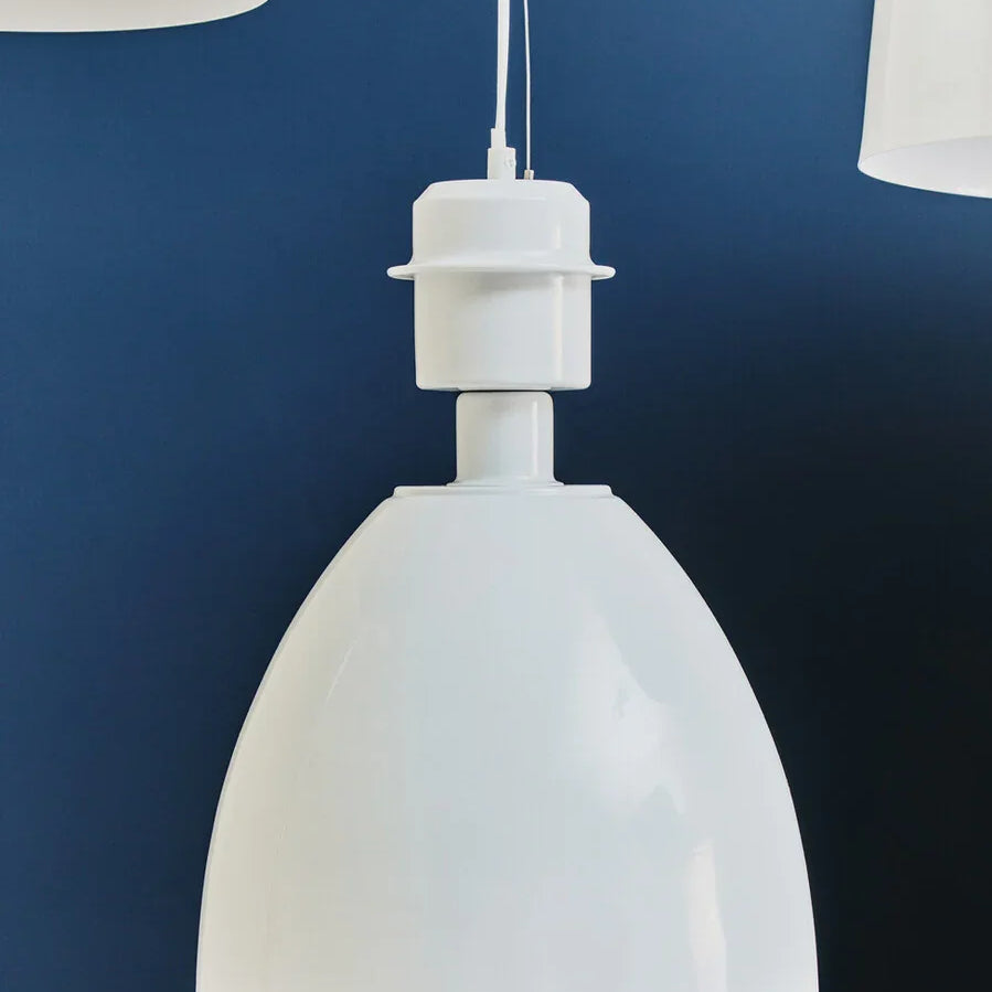 White pendant ceiling light with dome shade against blue wall