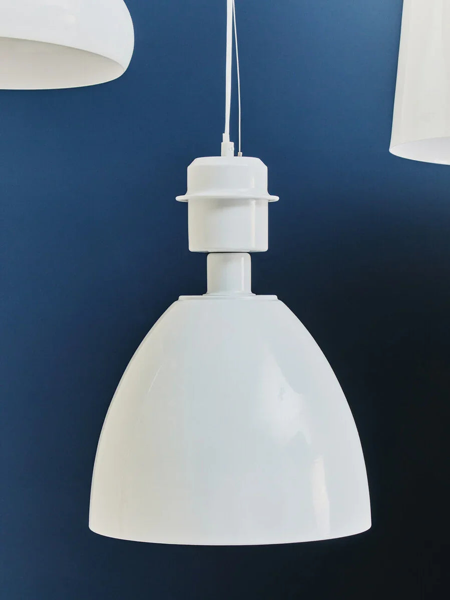 White pendant ceiling light with dome shade against blue wall