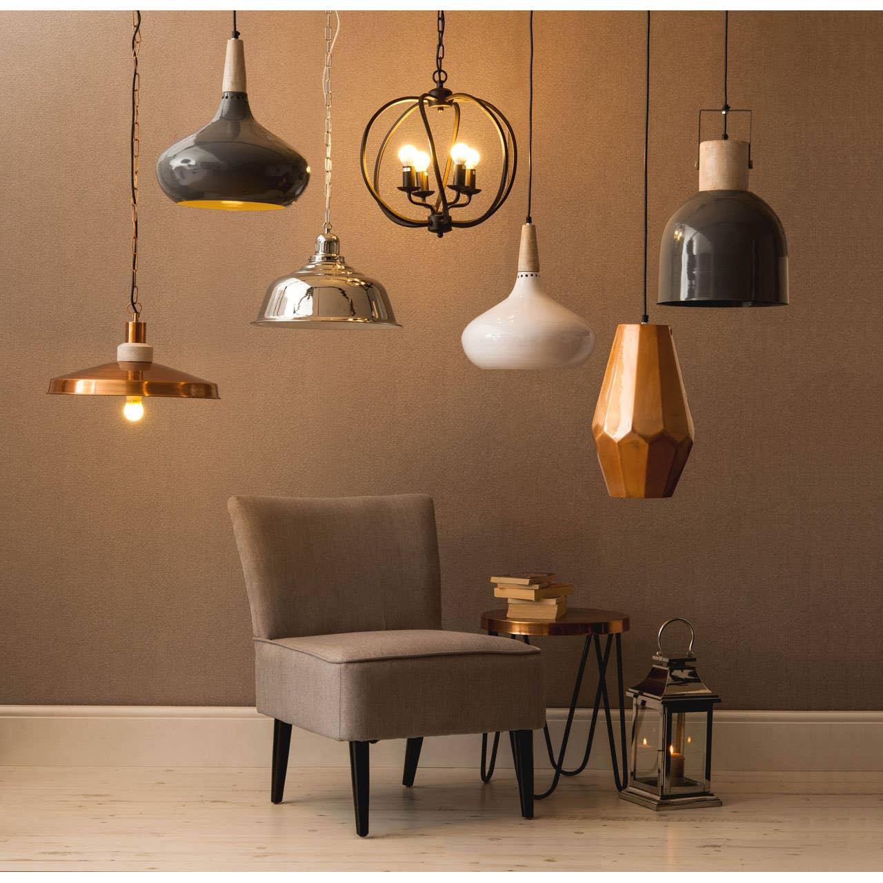 Pendant ceiling lights in brass, black, chrome and white above accent chair and side table