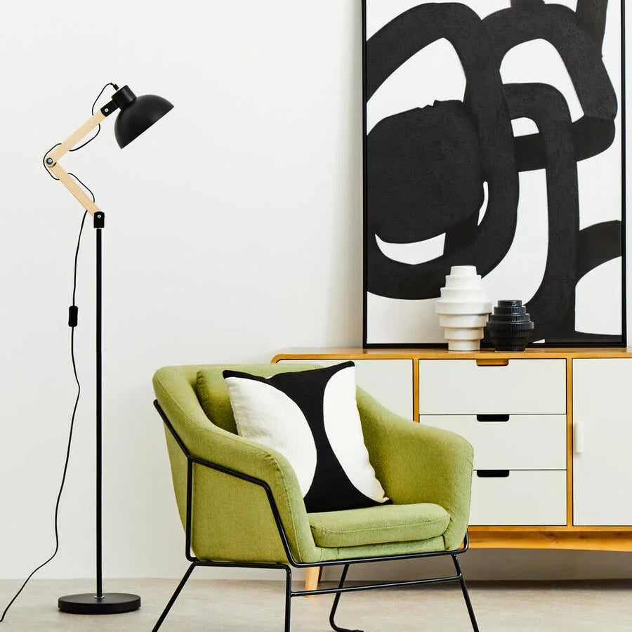 Green upholstered accent chair with black metal legs in modern living room setup