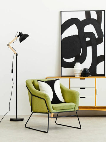 Green upholstered accent chair with black metal legs in modern living room setup