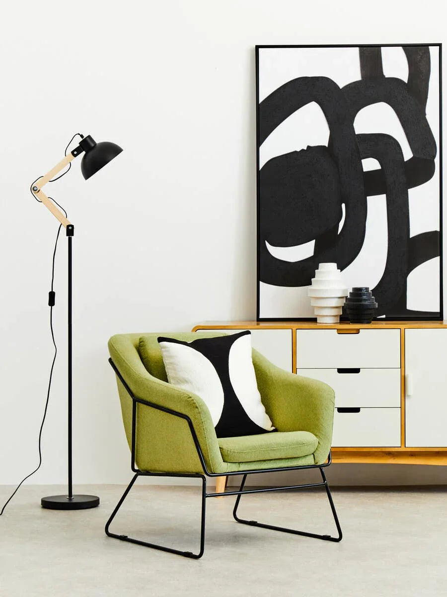 Green upholstered accent chair with black metal legs in modern living room setup