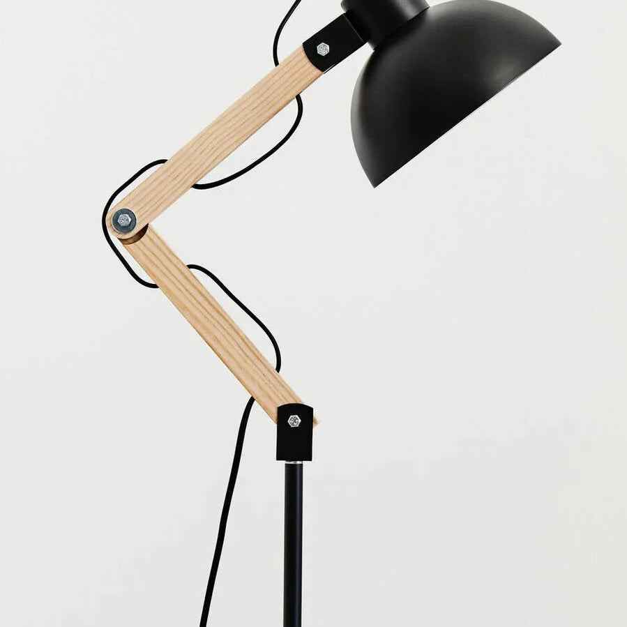 Adjustable black metal and wood floor lamp with exposed joints and cord