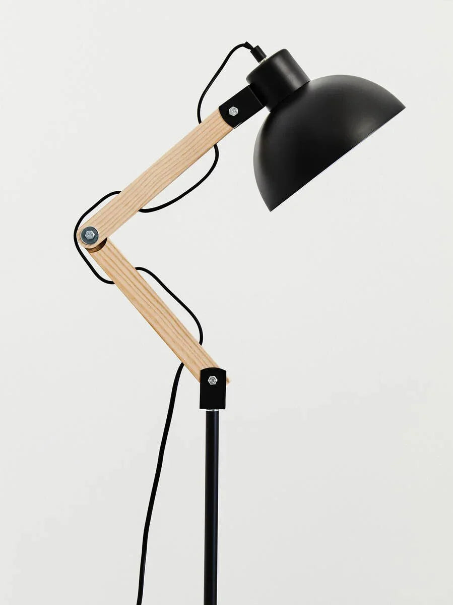 Adjustable black metal and wood floor lamp with exposed joints and cord