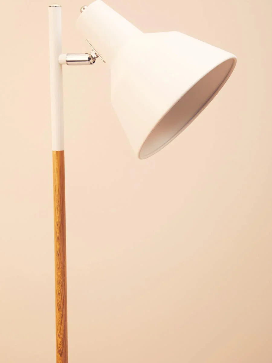 White metal floor lamp with wooden stand and adjustable shade against beige background