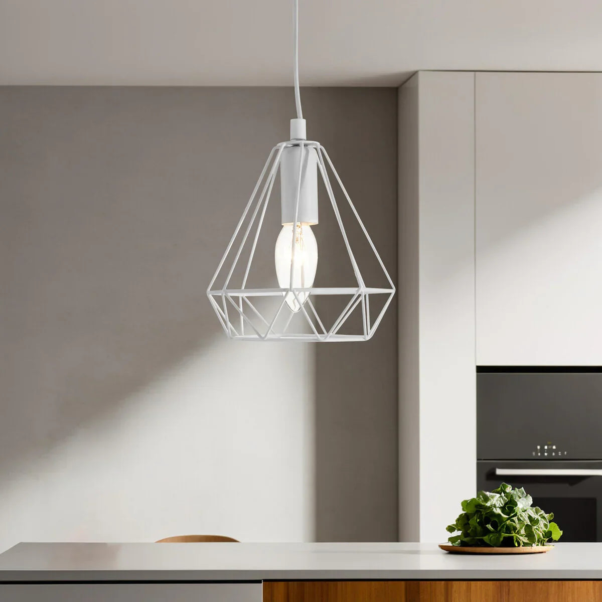 White geometric pendant light over modern kitchen island with green plant decor
