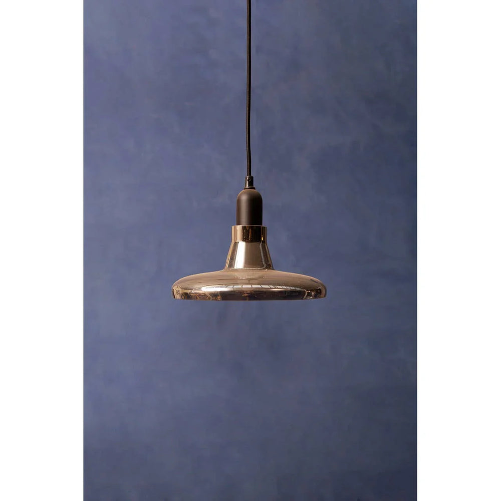 Modern glass pendant light with black fitting against a blue textured wall