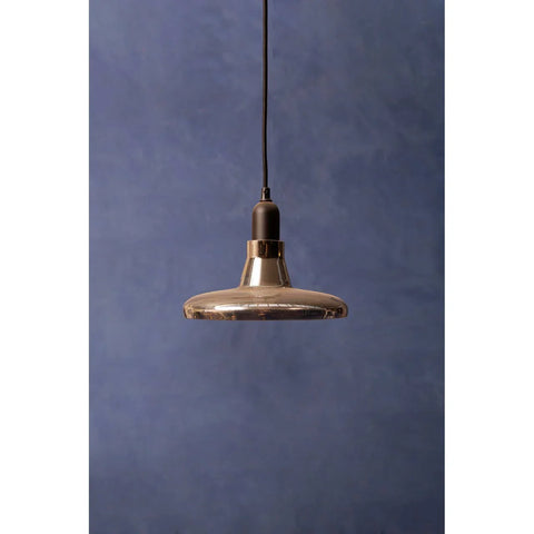 Modern glass pendant light with black fitting against a blue textured wall