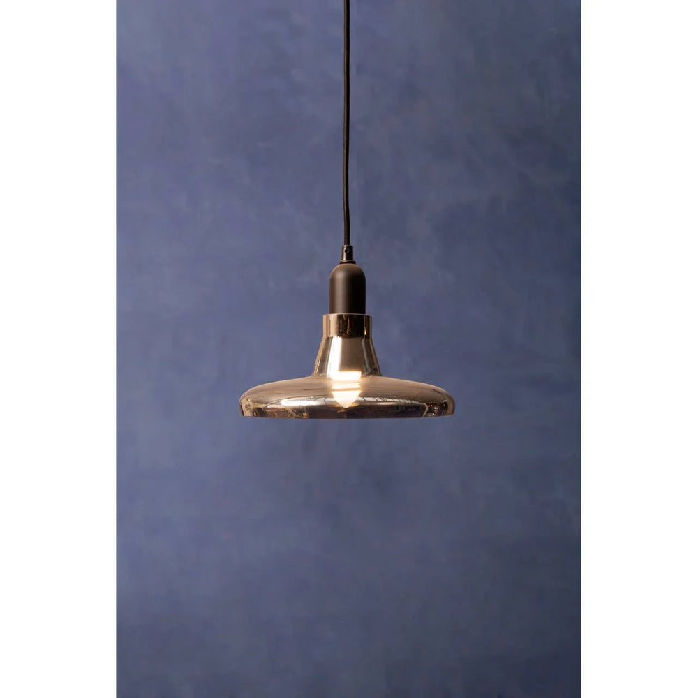 smoked glass pendant light with black cord against blue wall