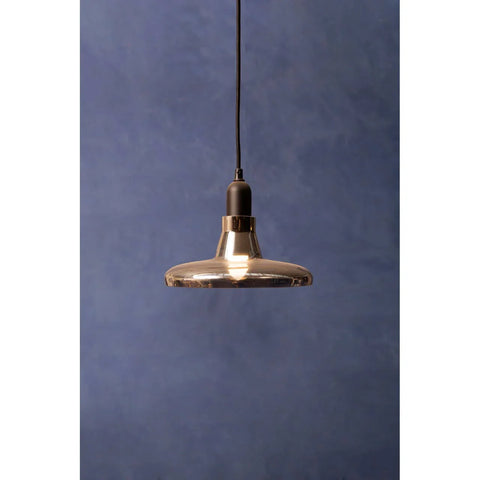 smoked glass pendant light with black cord against blue wall