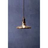 smoked glass pendant light with black cord against blue wall